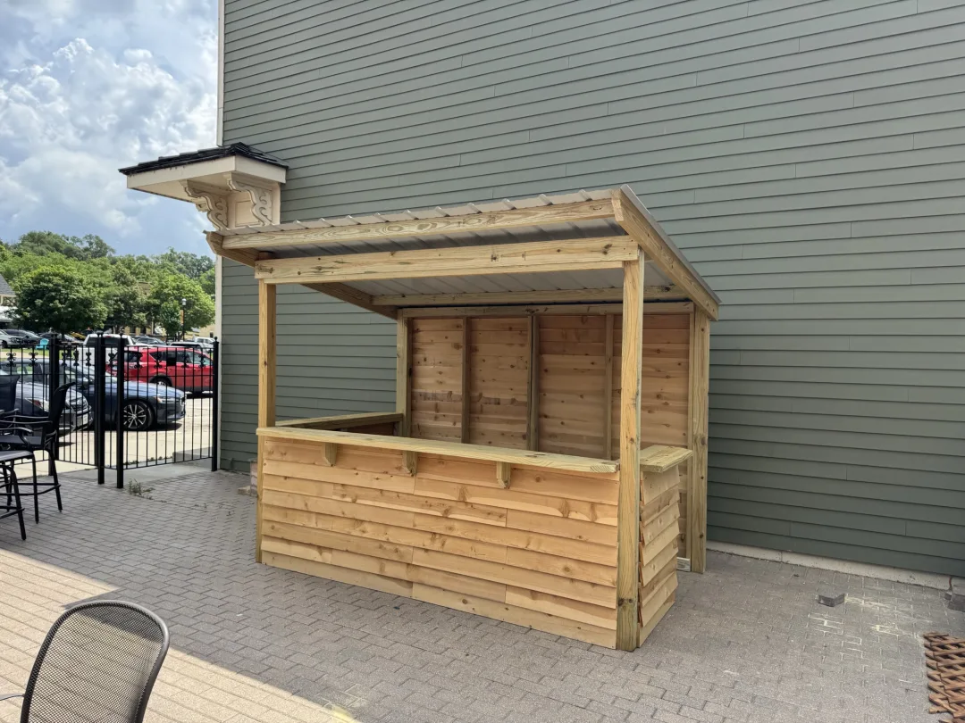 Backyard bar installation showing wraparound serving ledge and weather-ready wood detailing