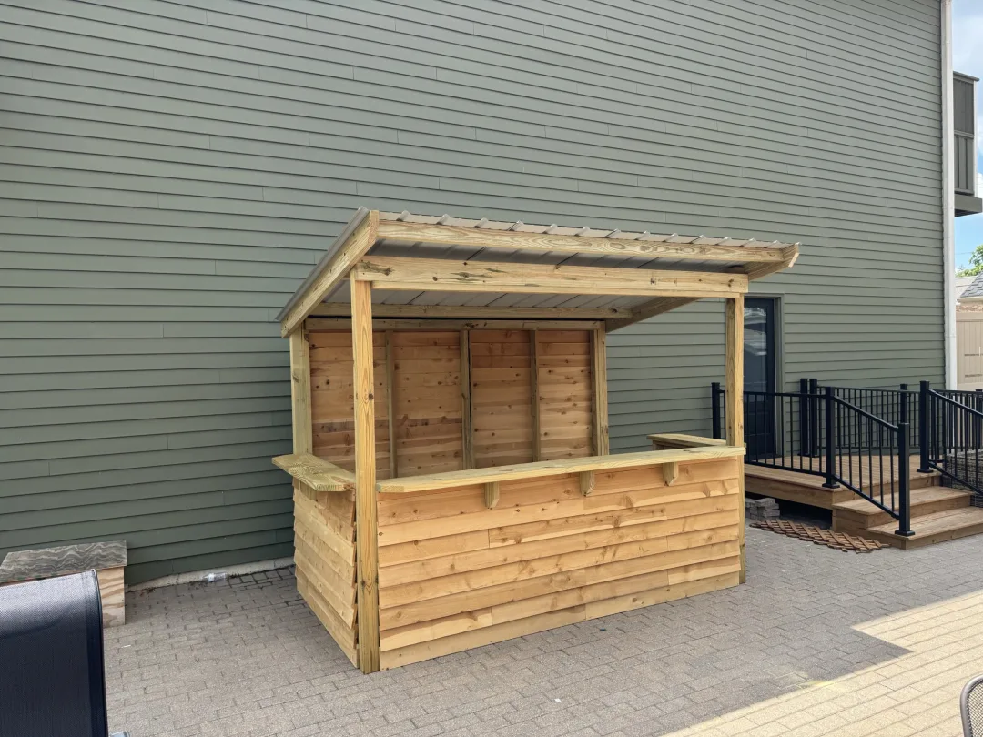Custom outdoor bar build with open guest-facing front and sheltered prep side